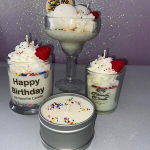 May include: Three candles in glass jars and a tin container. The candles are topped with white frosting and colorful sprinkles. The glass jars have labels that say "Happy Birthday My Favorite Candle" and "My Favorite Candle".