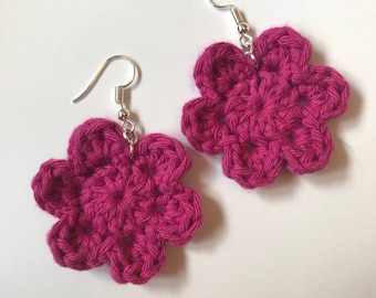 May include: A pair of pink crocheted flower earrings with silver hooks.