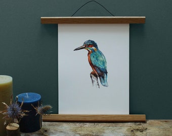 May include: A watercolor painting of a kingfisher perched on a branch, framed in a natural wood frame with a hanging wire.