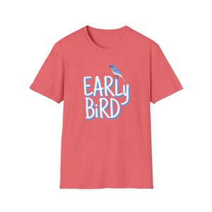 Può includere: Una t-shirt rosa corallo con un'immagine di un uccello blu e il testo "EARLY BIRD" in bianco con un contorno blu.