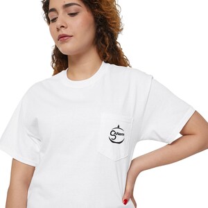 Può includere: Maglietta bianca con una tasca nera che presenta un logo che dice "CANem" in un cerchio.