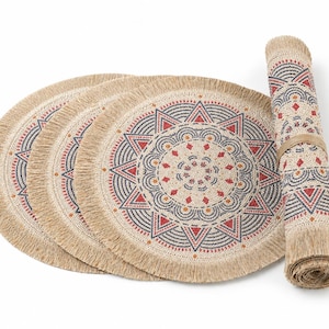 Può includere: Un set di quattro tovagliette rotonde e un runner abbinato arrotolato. Le tovagliette e il runner beige presentano un motivo geometrico in rosso, blu navy e arancione. Ogni tovaglietta ha un bordo sfrangiato.