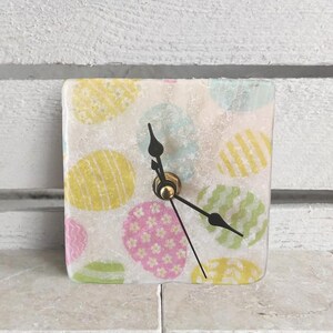Clock made of marble tile including wooden stand, small table clock, shelf clock, for Easter with colorful and decorated Easter eggs