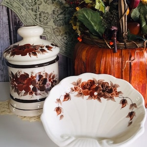 May include: A set of two vintage ceramic dishes with a brown and white floral pattern. The dishes are in the shape of a shell and a jar.
