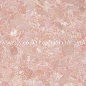 May include: Pink and white crystal slab with a smooth, polished surface. The slab is made of many small, irregular pieces of crystal that have been glued together.