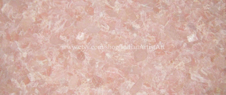 May include: Pink and white crystal slab with a smooth, polished surface. The slab is made of many small, irregular pieces of crystal that have been glued together.