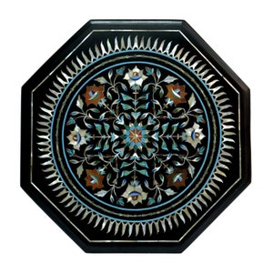 May include: Octagonal black marble table top with intricate inlaid floral design in mother of pearl, turquoise, and other colorful stones.