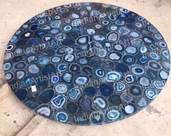 May include: Round blue agate table top with a unique design of blue and black agate slices. The table top is made of natural stone and has a polished finish.