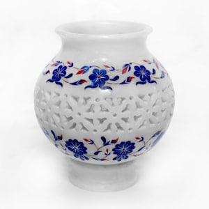 May include: White marble vase with intricate cut-out designs and blue and red floral patterns.