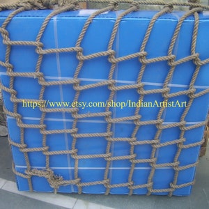 May include: A blue rectangular box wrapped in a thick brown rope net. The net is tied securely around the box, creating a grid pattern. The text "https://www.etsy.com/shop/IndianArtistArt" is visible on the box.