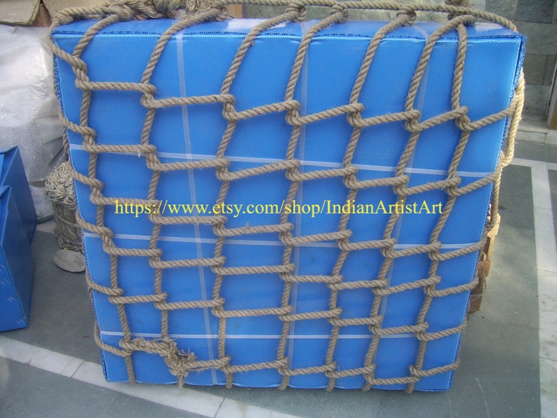 May include: A blue rectangular box wrapped in a thick brown rope net. The net is tied securely around the box, creating a grid pattern. The text "https://www.etsy.com/shop/IndianArtistArt" is visible on the box.