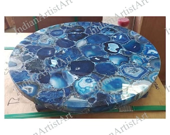 May include: Round blue agate table top with a polished finish. The table top is made of many small pieces of agate that have been cut and polished to create a unique and beautiful design.