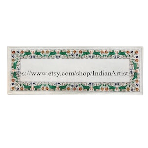 May include: A white marble table top with a decorative border of green, blue, and orange mosaic tiles. The border features a repeating pattern of birds and flowers. The text "https://www.etsy.com/shop/IndianArtistA" is visible in the center of the table top.
