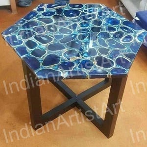 Op de afbeelding: Zeshoekige salontafel met een blauw agaatstenen blad en een zwarte metalen basis.