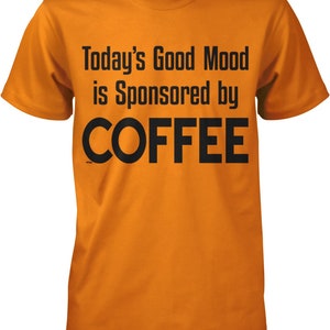 May include: Orange t-shirt with black text that reads "Today's Good Mood is Sponsored by COFFEE".