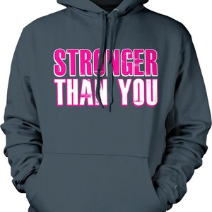 May include: A dark blue hooded sweatshirt with the words "STRONGER THAN YOU" printed in pink on the front.