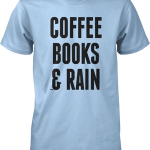 May include: Light blue t-shirt with black text that reads "COFFEE BOOKS & RAIN".