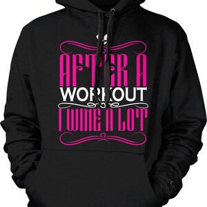 May include: Black hooded sweatshirt with the text "AFTER A WORKOUT I WINE A LOT" in pink and white. The sweatshirt has a drawstring hood and a front pocket. A casual garment for everyday wear.