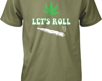 May include: An olive green short-sleeve t-shirt featuring a graphic print of a green cannabis leaf above the white text "LET'S ROLL" and a white illustration of a lit, smoking joint with three small smoke lines rising from the end.