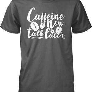 May include: A dark gray t-shirt with white text that reads "Caffeine Now Talk Later" and a graphic of coffee beans.