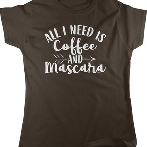 May include: Brown t-shirt with white text that reads "All I need is Coffee and Mascara" with an arrow pointing to the right.