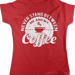 May include: Red t-shirt with a white distressed graphic that says "Never stand between me and my coffee" with a coffee cup and steam design.