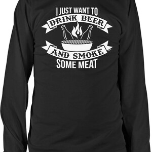 May include: Black long-sleeve t-shirt with white text that reads "I just want to drink beer and smoke some meat". The text is surrounded by a graphic of a grill with flames and two beer bottles.