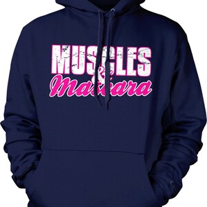 May include: Navy blue hooded sweatshirt with a white and pink graphic that says "MUSCLES & mascara".