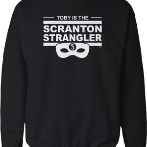 May include: Black sweatshirt with white text that reads "Toby is the Scranton Strangler" with a white mask and the letter "S" in the middle.