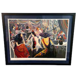 May include: A framed print of a colorful interior scene with figures in a restaurant or cafe. The artwork features women in hats, seated at tables, and other patrons in the background. The style is reminiscent of impressionist art.
