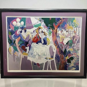 May include: Framed art print depicting a colorful outdoor cafe scene. The artwork features figures seated at tables, with a tree and an umbrella providing shade. The color palette includes purples, blues, and greens.