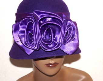 May include: A purple felt hat with a large purple satin flower accent.