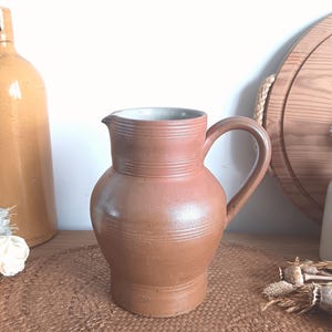 May include: A set of three ceramic mugs with a speckled, matte finish. Each mug features a different color: light blue, cream, and gray. The mugs have a simple, modern design and a comfortable handle.