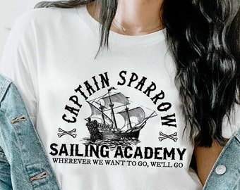 May include: White t-shirt with a black graphic of a ship and the text "Captain Sparrow Sailing Academy" and "Wherever we want to go, we'll go."
