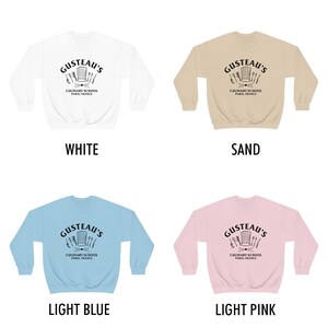 May include: Four crewneck sweatshirts in different colors: white, sand, light blue, and light pink. Each sweatshirt features a black and white graphic of a chef's hat and kitchen utensils with the text "Gusteau's Culinary School Paris, France".