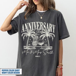 K&ouml;nnte beinhalten: Ein graues T-Shirt mit einem Vintage-Design mit Palmen, Cocktails und dem Text "Anniversary Club Est. 2006 Mr & Mrs Smith Miami, FL".