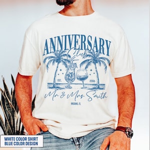 K&ouml;nnte beinhalten: Ein wei&szlig;es T-Shirt mit einem blauen Design mit Palmen, Cocktails und dem Text "Anniversary Club Est. 2006 Mr & Mrs Smith Miami, FL"