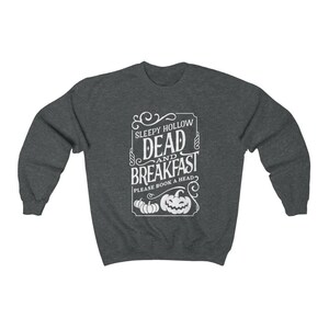May include: A dark heather gray sweatshirt with a white graphic design that says "Sleepy Hollow Dead and Breakfast" with a pumpkin design and the text "Please book a head".
