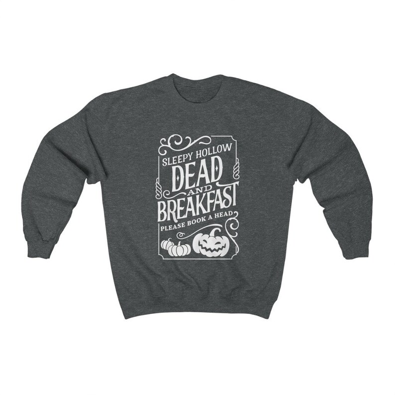 May include: A dark heather gray sweatshirt with a white graphic design that says "Sleepy Hollow Dead and Breakfast" with a pumpkin design and the text "Please book a head".