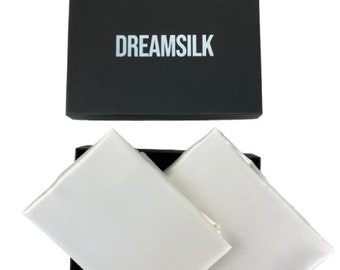 May include: Two white silk pillowcases in a black box with the word "DREAMSILK" printed on the box.