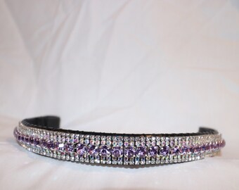 May include: A black leather horse browband with a triple row of clear and purple rhinestones.