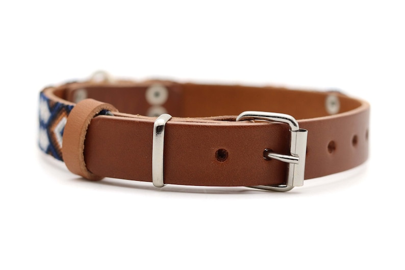 Peut inclure: Collier pour chien en cuir marron avec une section &agrave; motifs bleus, blancs et orange. Il est dot&eacute; d'une boucle argent&eacute;e et de rivets m&eacute;talliques. Un accessoire &eacute;l&eacute;gant pour animaux de compagnie.