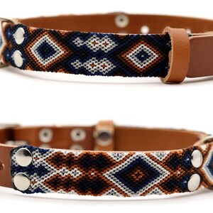 Peut inclure: Deux colliers pour chien en cuir marron avec un motif tiss&eacute; bleu marine, blanc et marron. Les colliers ont une garniture argent&eacute;e, dont un anneau en D et une boucle. La section tiss&eacute;e pr&eacute;sente un motif de losanges.
