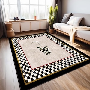 May include: Black and white checkered area rug with a black border and a gold trim. The rug features a white orchid in a black and white checkered pot in the center.