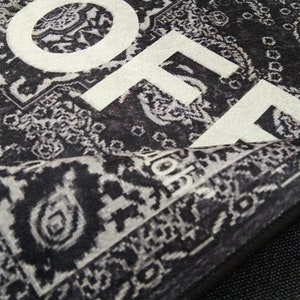 May include: Black and white patterned rug with the word "HOME" printed in white on the surface.