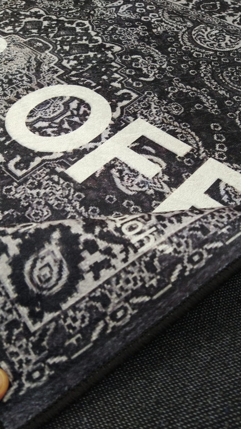 May include: Black and white patterned rug with the word "HOME" printed in white on the surface.