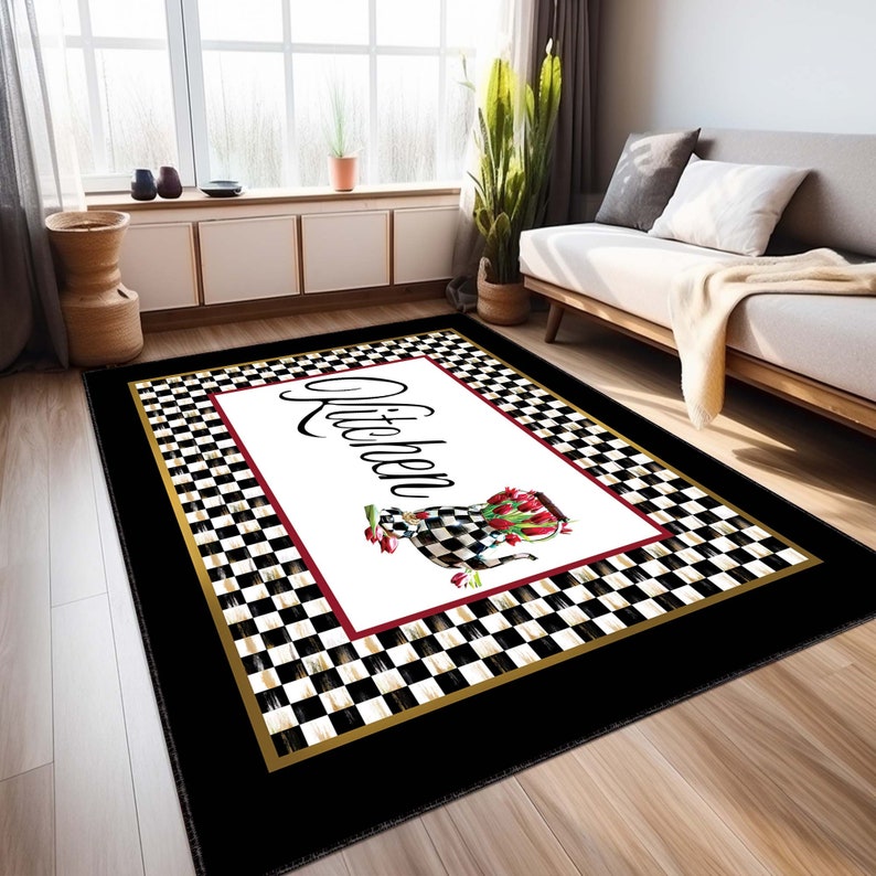 May include: A rectangular area rug featuring a central white panel with the word Kitchen in black script, a checkered teapot filled with red tulips, and a red border. The rug has a black and white checkered frame with a gold trim and black border.
