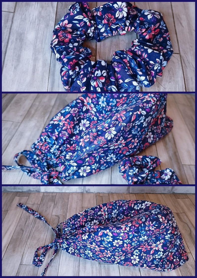 May include: A navy blue fabric scrub cap and matching scrunchie featuring a floral pattern with pink, white, and light blue petals and green leaves. The scrub cap has a rounded top, a gathered back, and two fabric ties for securing the fit.