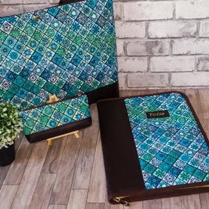 May include: Three matching bags with a blue and green geometric pattern. The largest bag is a tote bag, the middle bag is a clutch, and the smallest bag is a zippered binder with the word "Perdue" printed on the front.