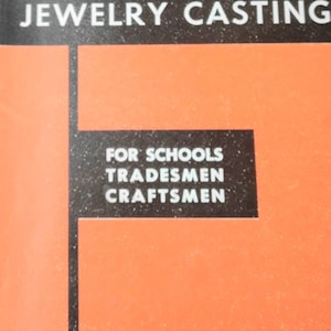 May include: A book titled "Centrifugal or Lost Wax Jewelry Casting" for schools, tradesmen, and craftsmen by Murray Bovin. The cover is orange with black text.